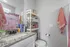 Charming bathroom with a sleek granite countertop, vibrant cheetah-print shower curtain, and organized shelving for a stylish and functional space.