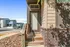 Charming entryway of modern home featuring rustic wooden steps, elegant brick facade, and contemporary siding that exude welcoming warmth.