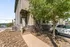 Charming townhouse entrance with rustic brick exterior, surrounded by lush greenery and a modern landscape design.