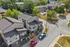 Charming aerial view of modern townhouses nestled in a tree-lined neighborhood, offering a blend of contemporary architecture and serene living.