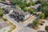Charming aerial view of a modern suburban neighborhood showcasing neatly arranged townhouses surrounded by lush greenery and ample parking spaces.