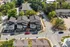 Aerial view of a charming residential community showcasing modern townhouses with stylish architecture, lush greenery, and spacious surroundings.
