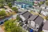 Aerial view of modern residential community with stylish duplexes, vibrant trees, and ample parking, showcasing a charming neighborhood vibe.