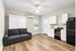 Modern studio apartment boasting sleek hardwood floors, a compact kitchen, and a convertible sofa, offering both style and functionality.