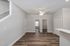 Bright and modern living space with sleek hardwood floors, ceiling fan, and neutral tones, offering an inviting open-concept layout.