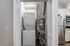 Modern apartment with in-unit laundry, featuring a sleek stacked washer and dryer in a bright, open closet next to a stylish kitchen with stainless steel appliances.