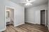 Bright bedroom with elegant wood flooring, ceiling fan, and en-suite bathroom, offering comfort and style.