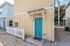 Charming modern home with vibrant turquoise door, welcoming entryway, and cozy white picket fence.