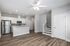 Modern open-concept kitchen with stainless steel appliances, sleek white cabinetry, and stylish wood flooring in a bright and inviting space.