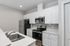 Modern kitchen with sleek white cabinetry, stainless steel appliances, and elegant countertops.
