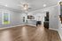 Spacious open-concept living area with elegant hardwood floors, modern kitchen with dark wood cabinetry, and abundant natural light.