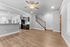 Elegant open-concept living space with hardwood floors, gourmet kitchen, and modern stairway, perfect for stylish living.