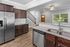 Elegant kitchen with dark wood cabinets, stainless steel appliances, and a granite countertop overlooking a bright living space.
