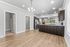 Modern open-concept kitchen with elegant wood flooring, stainless steel appliances, and stylish lighting features.