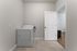 Modern laundry room featuring a sleek dryer, tile flooring, and convenient access to adjacent living spaces.