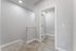 Bright and inviting hallway with carpeted stairs and a modern white door, offering a welcoming entrance to a comfortable home.