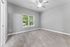 Bright and airy room with plush carpet, large window, and ceiling fan, providing a perfect canvas for your decor ideas.