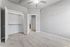 Bright and airy bedroom with plush carpet, open closet with double doors, and modern ceiling fan.