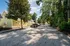 Charming homes with vibrant yellow exteriors set along a tree-lined driveway, offering a serene and welcoming neighborhood atmosphere.