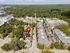 Beautiful aerial view of a vibrant neighborhood with a highlighted property, surrounded by lush greenery, urban architecture, and convenient amenities.
