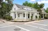 Charming corner property with classic white siding and wraparound porch, ideal for inviting curb appeal.