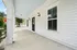 Charming house exterior with a spacious covered porch, white siding, and elegant outdoor lighting.