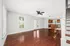 Bright and inviting open-concept living area with rich hardwood floors, featuring a modern kitchen with stainless steel appliances and elegant wooden cabinetry.