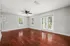 Bright and airy living room featuring elegant hardwood floors, large windows, and stylish French doors with abundant natural light.
