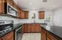 Elegant modern kitchen with rich wooden cabinets, sleek stainless steel appliances, and a spacious granite countertop.
