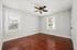 Inviting room with rich hardwood floors, neutral walls, and large windows offering ample natural light.