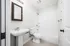 Modern bathroom featuring sleek white subway tiles, elegant fixtures, and a spacious shower-tub combination.