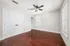 Bright, spacious room with elegant wood flooring, ceiling fan, and ample natural light through large windows.