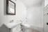Bright and modern bathroom featuring a clean bathtub, elegant pedestal sink, and stylish subway tile, perfect for relaxation.