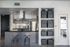 Modern kitchen with sleek countertops, stylish backsplash, and elegant storage solutions. Features stainless steel appliances and a cozy bar area with two stools.