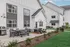 Inviting outdoor patio with modern seating, sleek barbecue grill, and lush green landscaping, perfect for entertaining.