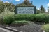 Inviting entrance sign of Albany Landing Apartments surrounded by lush greenery and vibrant landscaping.