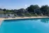 Inviting poolside view with stylish loungers and scenic lakeside backdrop at modern apartment complex.
