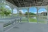 Charming gazebo overlooking a serene pond with lush greenery, offering a picturesque outdoor retreat.