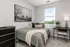 Inviting bedroom with a cozy bed, stylish decor, natural light, and serene outdoor views.