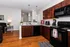 Inviting kitchen and living space featuring rich wooden cabinets, modern appliances, and elegant pendant lighting.