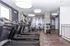 Modern apartment fitness center featuring state-of-the-art treadmills, exercise bikes, and weight racks in a sleek, well-lit space.
