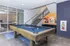 Chic community game room featuring a stylish pool table, vibrant artwork, and modern lounge seating, perfect for relaxation and socializing.
