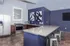 Contemporary kitchen with sleek granite countertops, modern stainless steel appliances, and stylish bar seating against a chic navy backdrop.
