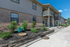 Charming apartment exterior with brick facade and vibrant landscaping, featuring a welcoming walkway and contemporary balcony design.