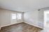 Bright and airy living room with elegant wood flooring, featuring large windows and a door letting in ample natural light.