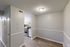 Chic apartment corner featuring a modern kitchen with stainless steel appliances and elegant white cabinetry.