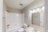 Bright, modern bathroom with sleek fixtures, a bathtub, and elegant lighting.