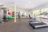 Bright and modern fitness center equipped with state-of-the-art workout machines, vibrant exercise balls, and large mirrors for an invigorating exercise experience.