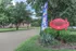 Charming entrance to Woodbridge Place, featuring lush greenery, a welcoming sign, and serene surroundings.