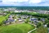 Breathtaking aerial view of a lush apartment complex featuring modern buildings, scenic ponds, and vibrant green landscapes, offering a serene living environment.